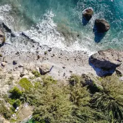 Vista aérea de la cala Barranco de Maro, con rocas, vegetación y el mar turquesa.
