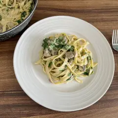 Pyszne fettuccine z kremowym sosem, pieczarkami i szpinakiem. Idealne danie na szybki obiad.