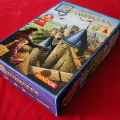 Pudełko gry planszowej Carcassonne, z motywem zamku i postaci, sugeruje nowe **carcassonne rozszerzenia**.