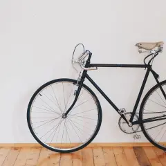Czarny rower z siodełkiem na sprężynach. Czy jego rama jest stalowa czy aluminiowa?