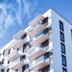Nowoczesny blok mieszkalny z balkonami i szklanymi balustradami. Idealne miejsce na Twój tytuł prawny do lokalu.