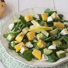 Deliciosa ensalada de lechuga con cubos de queso amarillo, aguacate, huevo cocido y semillas.