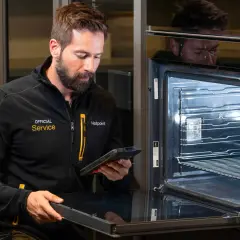 Serwisant z tabletem sprawdza instrukcję mastercook plus piekarnik.