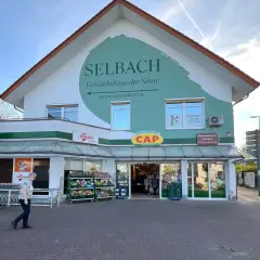 Ein Supermarkt und Gartencenter "Selbach" im Bergischen Land heute. Ein CAP-Markt und eine Metzgerei sind ebenfalls Teil des Gebäudes.