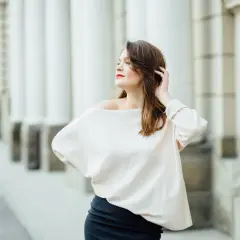 Kobieta w luźnej bluzce i spódnicy, idealne ubrania maskujące brzuch. Elegancka stylizacja na co dzień.
