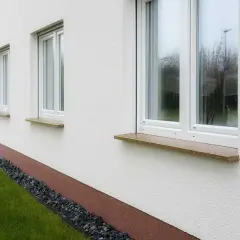 Eleganckie parapety kamienne w ciepłych kolorach dodają uroku białej elewacji.