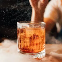 Elegancki boulevardier z lodem, otoczony mgiełką, w blasku światła.