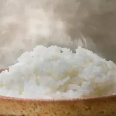 Heißer, dampfender Reis in einer Schale. Man fragt sich, wann ist Reis fertig, wenn er so frisch aussieht.