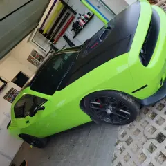 Jasnozielony Dodge Challenger z czarną maską i dachem, gotowy do oklejenia. Zastanawiasz się, ile kosztuje oklejenie auta?