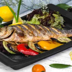 Apetyczna ryba z piekarnika z warzywami: grillowany bakłażan, cukinia, papryka, podana z sałatką i cytryną.
