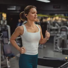 Frau läuft auf Laufband im Fitnessstudio. Sie fragt sich, wie oft Cardio in der Woche gut ist.