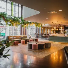 Mysig lounge med grönska och belysning, perfekt för en hotel Dorsia lunch.