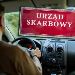 Kierowca w samochodzie zbliża się do Urzędu Skarbowego, być może w celu złożenia deklaracji PCC-3 od zakupu auta.