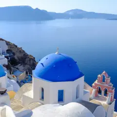 Błękitne kopuły kościołów na Santorini, idealne na wakacje. Marzysz o Santorini loty bezpośrednie?