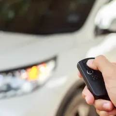 Dłoń trzyma kluczyk do samochodu, gotowa do uruchomienia silnika dzięki funkcji keyless go.