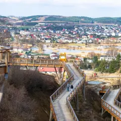 Drewniana wieża widokowa wije się wśród drzew, oferując panoramę miasteczka i jeziora.