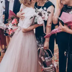Wzruszający moment na weselu: piosenka dla rodziców, bukiety i kosz prezentowy.