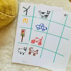 Dzieci rysują obrazki do zabawy w aucie: wiatrak, M, sygnalizację świetlną, owcę, krowę, auto, rower, kota.