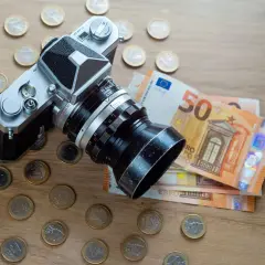 Fotografia stockowa: aparat analogowy otoczony monetami euro i banknotami 50 euro.