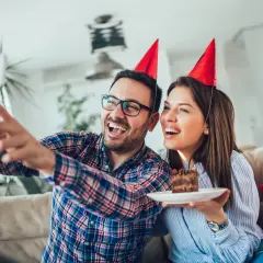 Para chrześniaka życzenia urodzinowe! Radośni rodzice z tortem i prezentami robią sobie selfie.