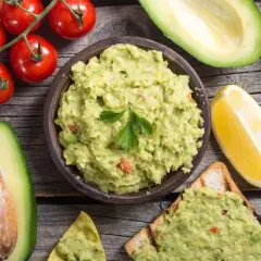 Miseczka guacamole, awokado, pomidorki i cytryna. Idealne składniki, by dowiedzieć się, co zrobić z guacamole – na toście lub nachos!