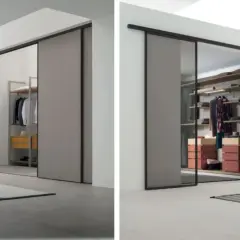 Porte scorrevoli per cabine armadio in cartongesso, con un'anta in vetro che rivela un interno ordinato e moderno.