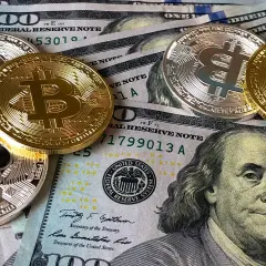 Złote i srebrne monety z symbolem Bitcoina leżą na banknotach dolarowych. Czy to przyszłość płatności w kantorze Santander Bank?