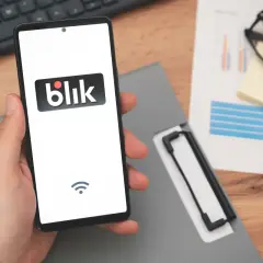 Dłoń trzyma smartfon z logo Blik. To szybki sposób na przelew blik na telefon jak odebrać pieniądze.