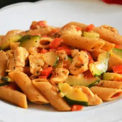 Penne z kurczakiem, cukinią i pomidorami w sosie. Pyszne dania z makaronem ryżowym i kurczakiem.