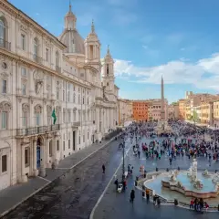 Una vivace piazza barocca a Roma, con la Fontana dei Quattro Fiumi al centro e la chiesa di Sant'Agnese in Agone sullo sfondo.