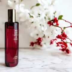 Elegancka butelka perfum Zara Red Temptation & Vanille, idealny odpowiednik dla miłośniczek zmysłowych zapachów, na tle delikatnych kwiatów.