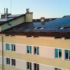 Budynek z panelami fotowoltaicznymi na dachu, wspierany przez Bank Gospodarstwa Krajowego.