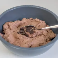Schokoladige Sahnecreme mit Schokodrops in einer grauen Schüssel, bereit zum Genießen.