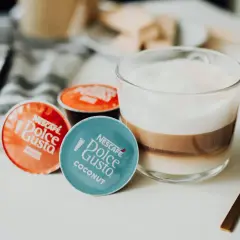 Kapsułki Dolce Gusto obok kawy z mlekiem. Może ekspres Dolce Gusto nie chce wyjąć kapsułki?
