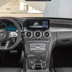 Interiör i en Mercedes W204 med sportratt, digital instrumentpanel och kolfiberdetaljer.