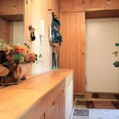 Stara boazeria aranżacje: przytulny przedpokój z lustrem, bukietem kwiatów i drzwiami.