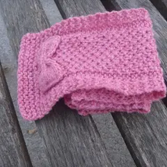 Sciarpa bimba ai ferri con fiocco, lavorata a maglia con schema semplice. Morbida e rosa, perfetta per l'inverno.