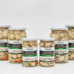 Sześć słoików z marynowanymi i w zalewie naturalnej pieczarkami, różnych rozmiarów.