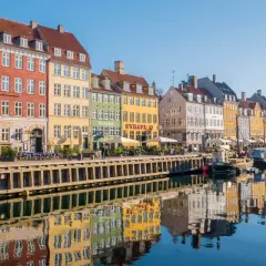 Kolorowe kamienice nad kanałem Nyhavn to obowiązkowy punkt na mapie kopenhaga co zobaczyć. Widać tu odbijające się w wodzie łodzie i budynki.