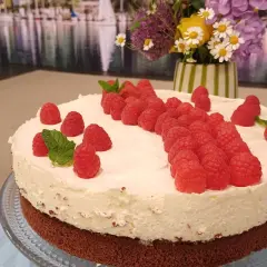 Himbeer Mascarpone Torte mit frischen Himbeeren und Minze verziert, ein Genuss für Augen und Gaumen.