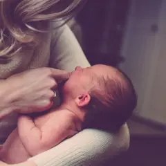 Mutter hält ihr Neugeborenes. Ashwagandha Stillzeit: sanfte Pflege für Mutter und Kind.