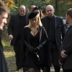 Kobieta w czerni, otoczona ochroniarzami, idzie na pogrzeb. Scena z filmu "Pitbull. Ostatni pies", obsada w żałobie.
