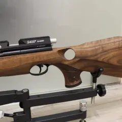 Elegancki karabin pneumatyczny Air Arms S510 z drewnianą osadą, prezentowany na statywie.