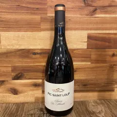 Bouteille de vin rouge du domaine Pic Saint Loup, "Réserve Les Almadies", sur fond de bois.