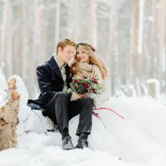 Para młoda w zimowej scenerii. Romantyczny ślub w grudniu w otoczeniu śniegu i drzew.
