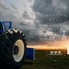 Trattore blu in un campo al tramonto, con icone che rappresentano l'agricoltura 4.0 esempi: IoT, pannelli solari, irrigazione e rete.
