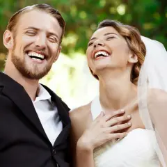 Coppia felice ride su un'altalena, perfetta per frasi per matrimonio e battesimo insieme.