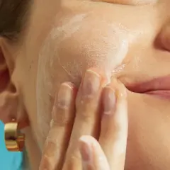 Mani delicate massaggiano schiuma sul viso, cercando sollievo per la pelle irritata.