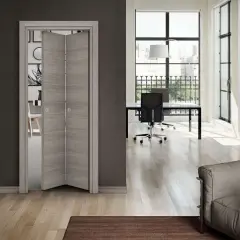 Montaggio porte interne a soffietto in legno chiaro, che dividono un soggiorno moderno da un ufficio luminoso con scrivania e poltrona.