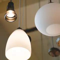 Varias lámparas cuelgan del techo, una con forma de lágrima y otra esférica, creando un ambiente acogedor con sus luces.
